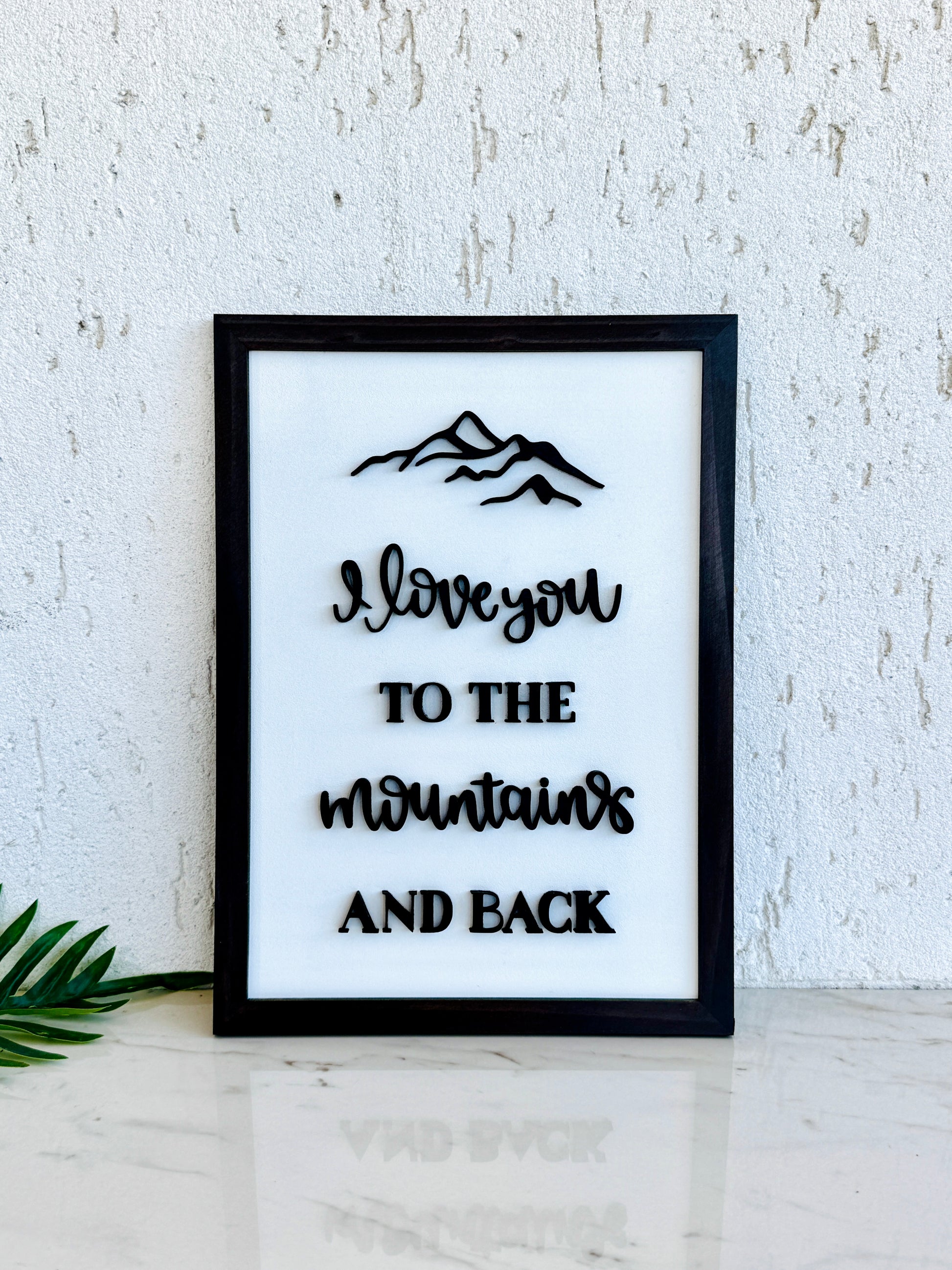 Framed print with 'I love you to the mountains and back' text on a white background