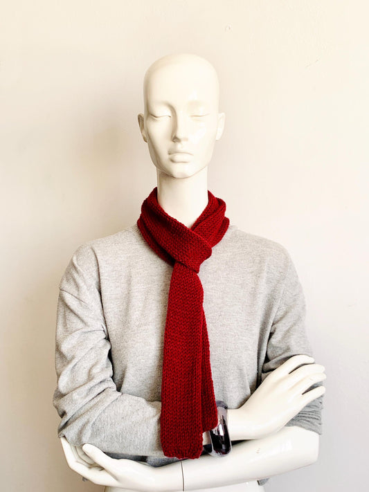 A mannequin wearing a maroon skinny knit scarf in a long style.