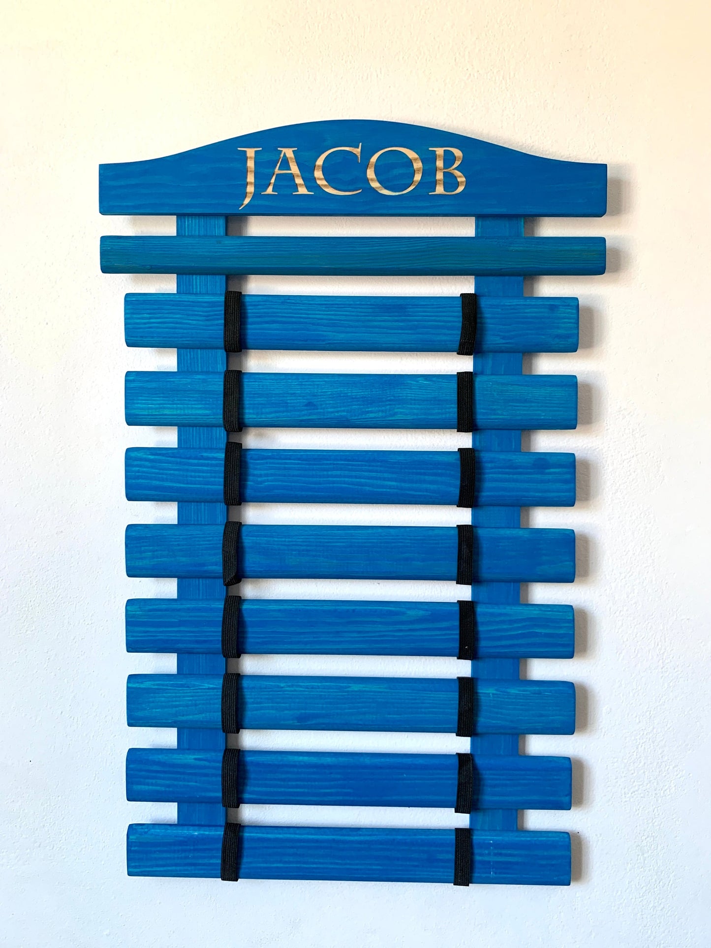 Personalized wooden martial arts belt display rack with engraved name, available in multiple colors and sizes (5-18 belts), perfect for Karate, Taekwondo, and Jiu-Jitsu practitioners.

